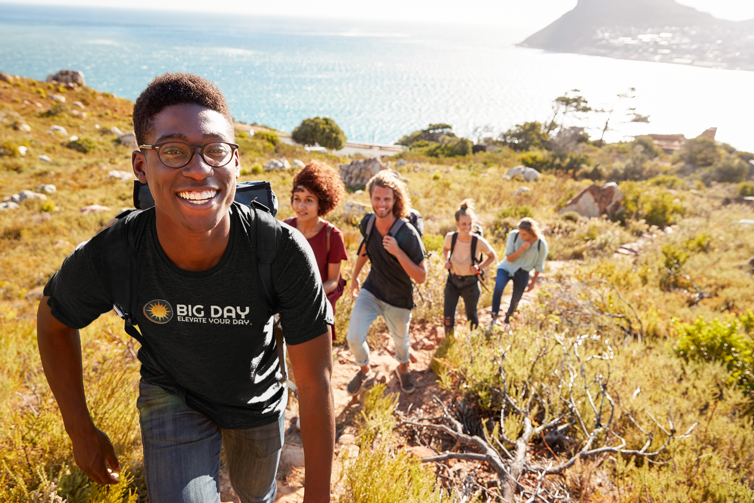 BIG DAY® Elevate Your Day Collection - Man hiking hill with friends wearing BIG DAY Elevate Your Day Black T-shirt