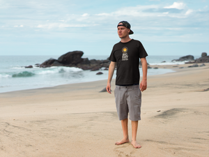 BIG DAY® Men's Tees and Apparel - man on beach wearing BIG DAY Elevate Your Day black tee